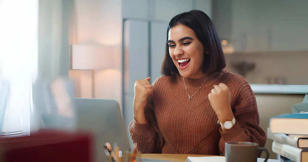 Cómo escribir logros en tu currículum (+ Ejemplos) mujer celebrando un logro muy importante
